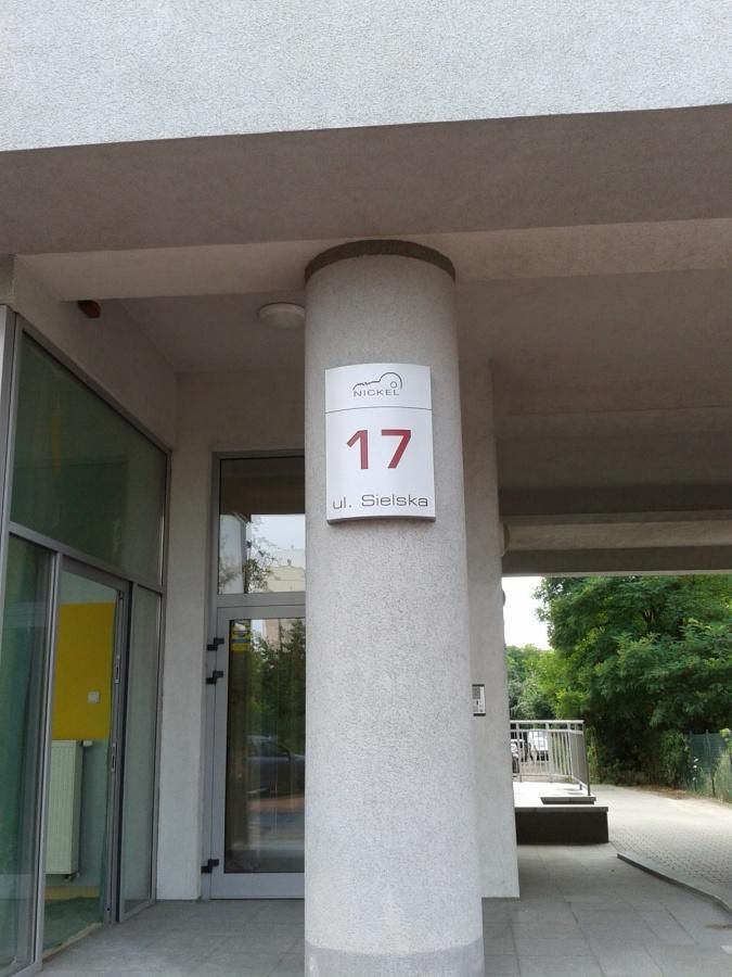 Wejście do budynku przy ul. Sielskiej 17 – tabliczka z numerem na okrągłym słupie